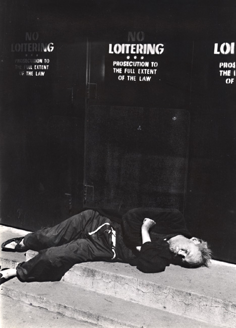 Bum Sleeping under a "No Loitering" sign in New York City, NY